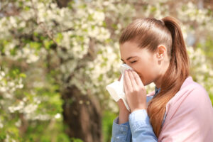 woman sneezing in the summer.